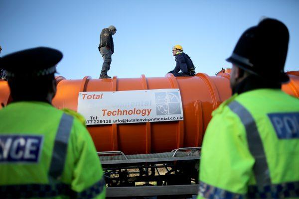 A policeman edges his way toward an anti-fracking protester standing on the top of a truck carrying chemicals to the Barton Moss gas fracking facility on Jan. 13, 2014, in Barton, England. (Christopher Furlong/Getty Images)