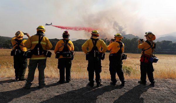 Firefighters watch as an air tanker drops fire retardant to protect homes along the crest of a hill at the River Fire (Mendocino Complex) near Lakeport, California, U.S. Aug. 2, 2018. (Reuters/Fred Greaves)