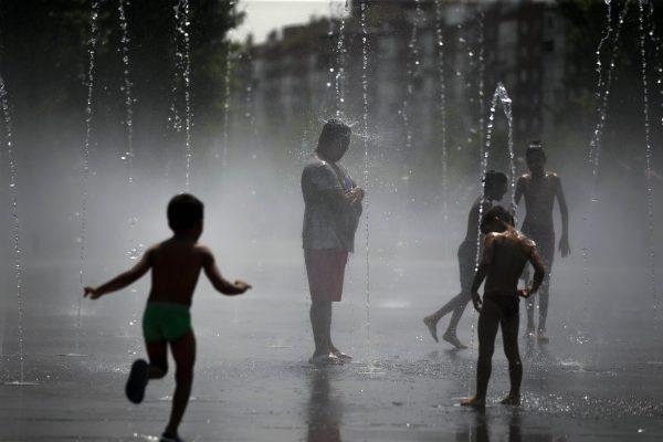 People cool off in an urban beach at Madrid Rio park in Madrid, Friday, Aug. 3, 2018. (AP Photo/Francisco Seco)