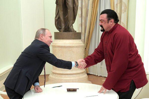 Russian President Vladimir Putin (L) shakes hands with U.S. action hero actor Steven Seagal after presenting a Russian passport to him during a meeting at the Kremlin in Moscow on November 25, 2016. (ALEXEY DRUZHININ/AFP/Getty Images)
