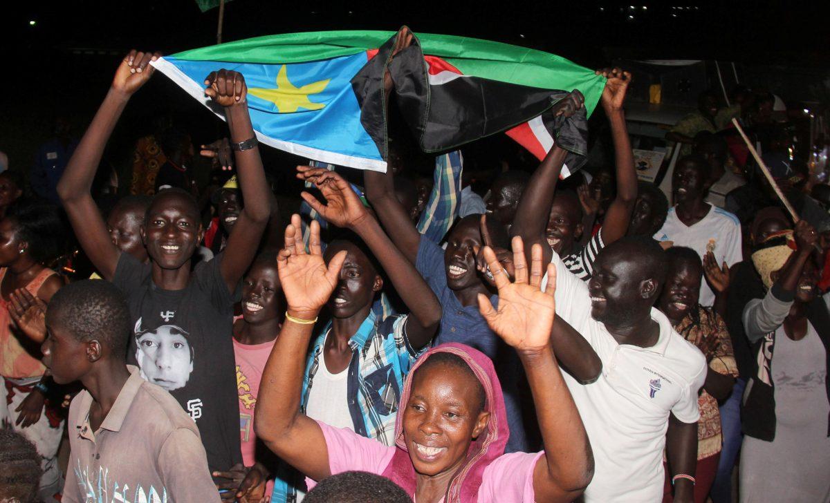 South Sudanese civilians carry their national flag as they celebrate the signing of a cease fire and power sharing agreement between President Salva Kiir and rebel leader Riek Machar, in Khartoum; along the streets of Juba, South Sudan August 5, 2018. (Reuters/Samir Bol)