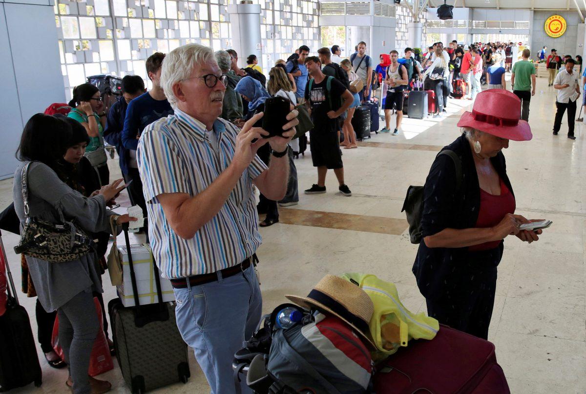Foreign tourists queue to leave Lombok Island after an earthquake hit, as seen at Lombok International Airport, Indonesia, August 6, 2018. (Reuters/Beawiharta)