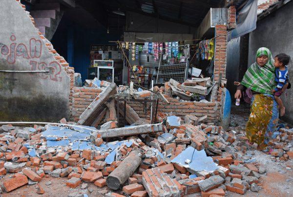 A woman walks past debris from a collapsed wall following a strong earthquake in Lendang Bajur Hamlet, Lombok island, indonesia on Aug. 6, 2018. (Antara Foto/Ahmad Subaidi/ via REUTERS)