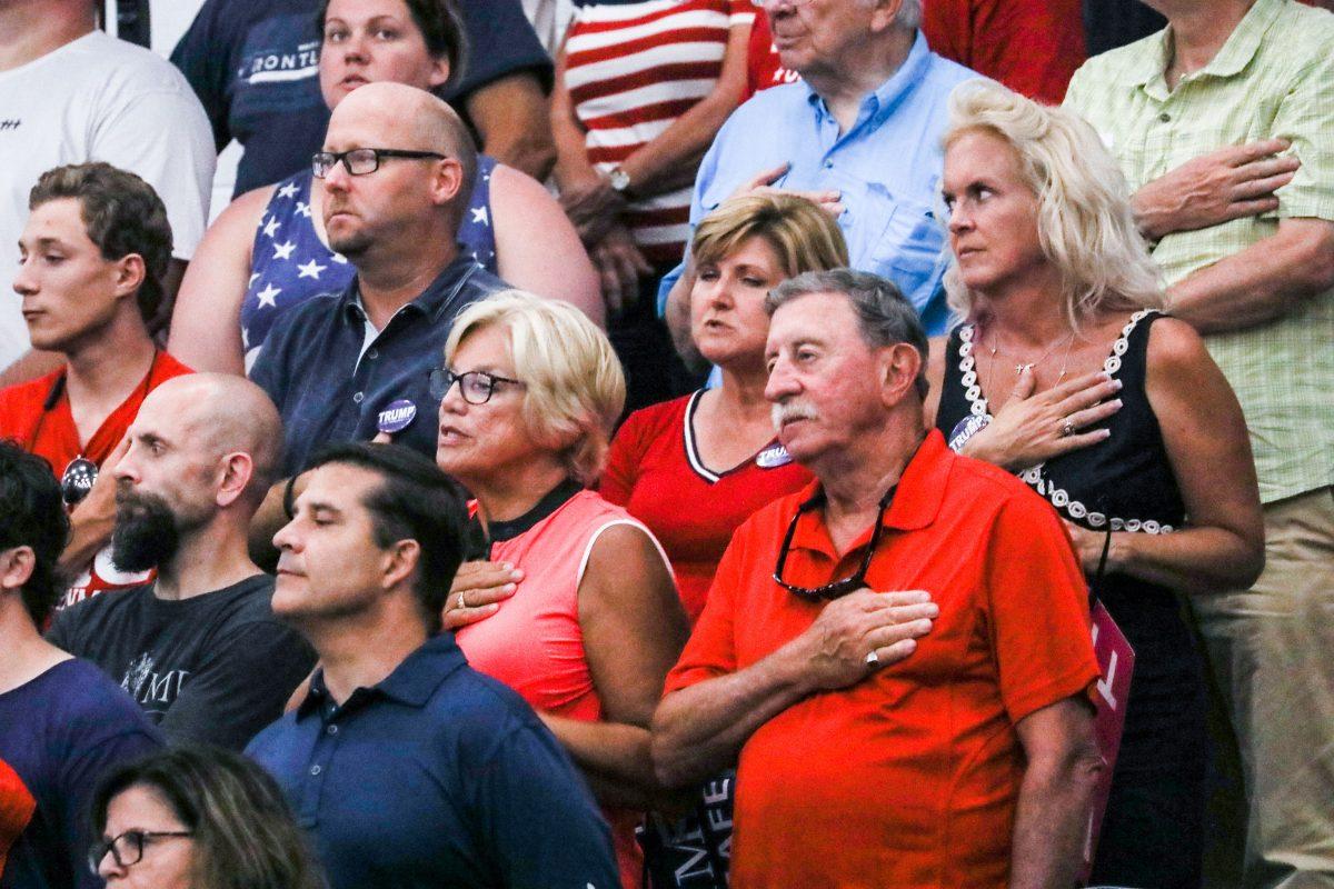 Audience members stand for the national anthem at a Make America Great Again rally in Lewis Center, Ohio, on Aug. 4, 2018. (Charlotte Cuthbertson/The Epoch Times)