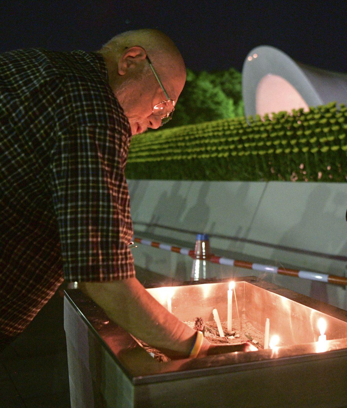 A man burns a stick of incense at the cenotaph dedicated to the victims of atomic bombing at Hiroshima Peace Memorial Park in Hiroshima, western Japan, early Monday, Aug. 6, 2018, marking the 73rd anniversary of the bombing. (Yohei Nishimura/Kyodo News/AP)