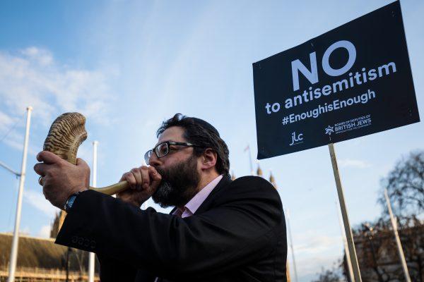 A protester blows through a shofar during a demonstration in Parliament Square against anti-Semitism in the Labour Party on March 26, 2018 in London, England. (Jack Taylor/Getty Images)