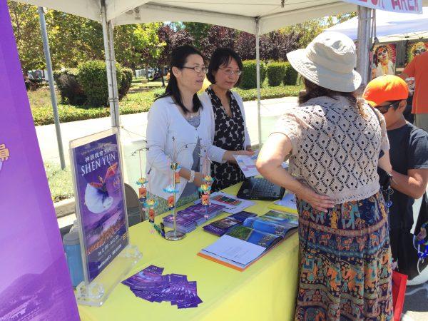 Sales representatives talking with people at the Shen Yun ticket booth during the Fremont Festival of the Arts on August 5, 2018 (EETSF).