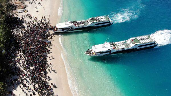 Boats arrive at shore to evacuate people on the island of Gili Trawangan, Lombok, Indonesia, Aug. 6, 2018, in this still image taken from a drone video obtained from social media. (Melissa Delport/@trufflejournal/via Reuters)