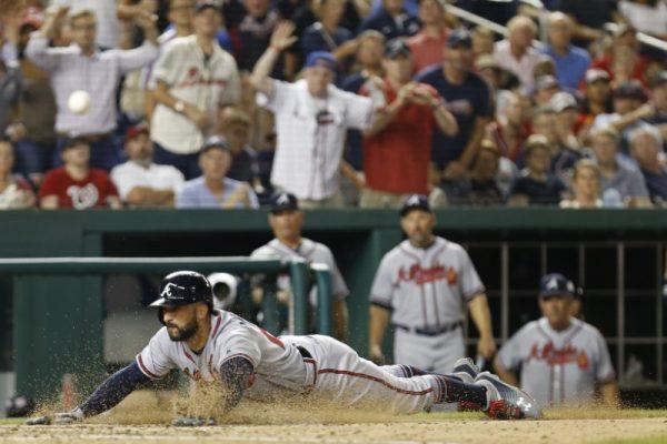 Aug 7, 2018; Washington, DC; Atlanta Braves right fielder Nick Markakis slides across home plate to score a run on a two run triple by Braves center fielder Ender Inciarte (not pictured) against the Washington Nationals in the ninth inning at Nationals Park. The Braves won 3-1. (Geoff Burke-USA TODAY Sports)