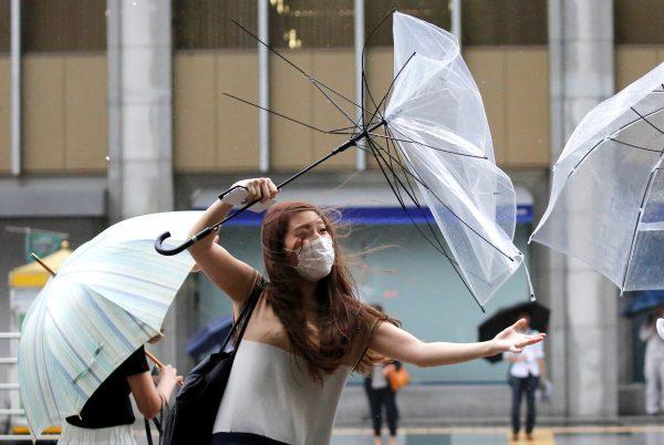 A woman using an umbrella struggles against a heavy rain and wind as Typhoon Shanshan approaches Japan's mainland in Tokyo, Japan Aug. 8, 2018. (Reuters/Toru Hanai)