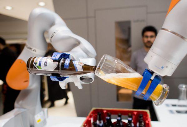 Robots from the company Kuka serve non-alcoholic beer during the Hannover Fair in Hanover, Germany, on April 23, 2018. (JULIAN STRATENSCHULTE/AFP/Getty Images)