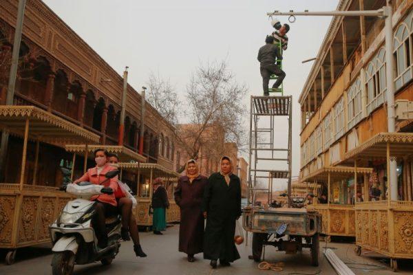 Men install a CCTV camera in a shopping street in the old town of Kashgar, Xinjiang Uighur Autonomous Region, China. (Reuters/Thomas Peter)