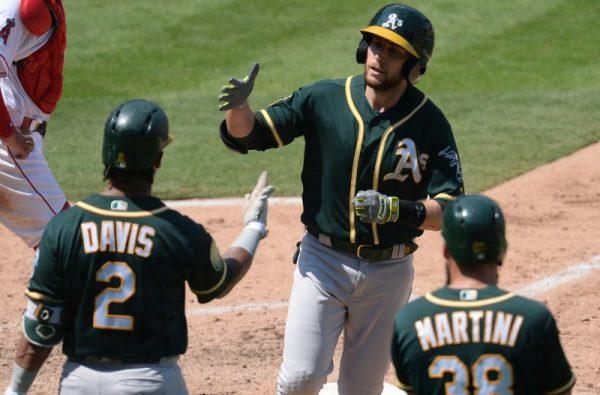 Oakland Athletics second baseman Jed Lowrie is greeted by left fielder Khris Davis and right fielder Nick Martini after hitting a two run home run against the Los Angeles Angels in the fourth inning. (Gary A. Vasquez/USA Today Sports)