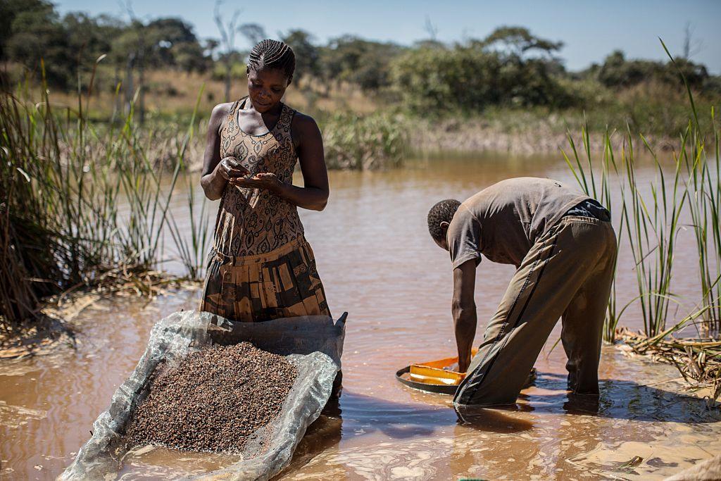 A woman and a man separate cobalt from mud and rocks near a mine between Lubumbashi and Kolwezi, Democratic Republic of the Congo, on May 31, 2015. (Federico Scoppa/AFP/Getty Images)
