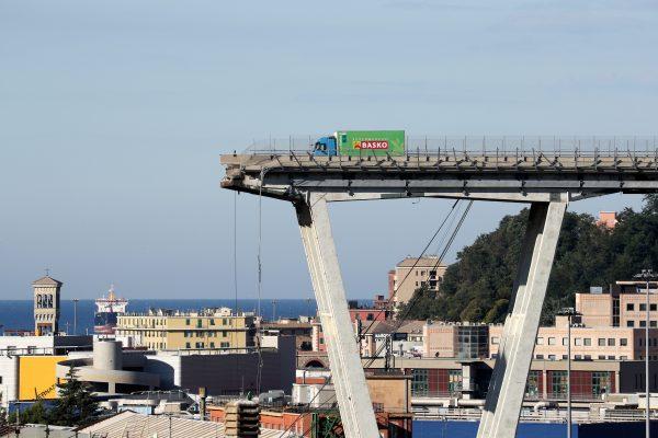 An abandoned vehicle sits atop a section of the collapsed Morandi Bridge in Genoa, Italy, Aug. 15, 2018. (Reuters/Stefano Rellandini)