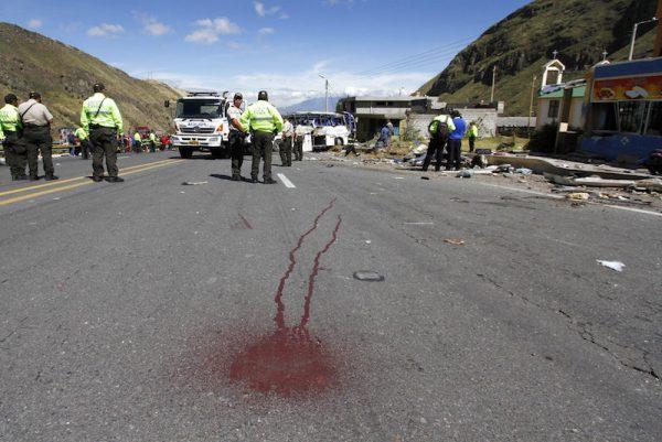 Police officers block traffic at the site where a Colombian-registered bus traveling to Quito crashed in Pifo, Ecuador, Tuesday, Aug. 14, 2018. At least 24 people were killed and another 19 injured when a bus careened into another vehicle at high speed and overturned along the Pifo-Papallacta highway, near Ecuador's capital, local officials reported. (AP/Carlos Noriega)