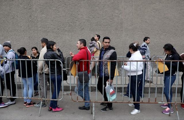 Venezuelan migrants wait at the Interpol headquarters to get paperwork needed for a temporary residency permit, in Lima, Peru, August 16, 2018. (Reuters/Mariana Bazo)