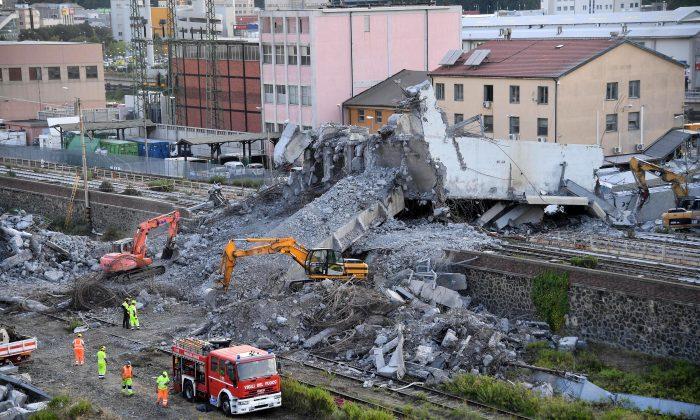 Firefighters remove debris of the collapsed Morandi highway bridge in Genoa, Italy, on Aug. 16, 2018. (Luca Zennaro/ANSA via AP)