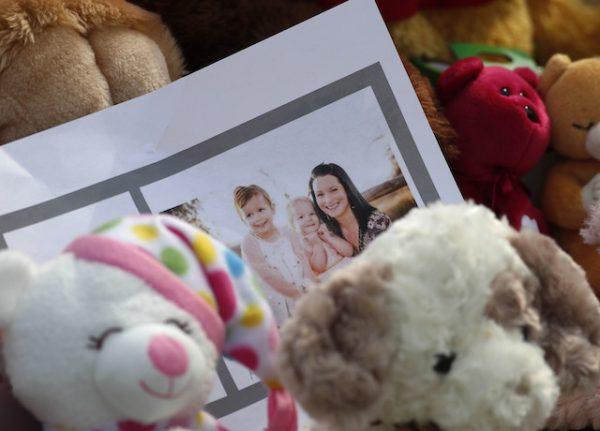 A photograph sits amid the tributes outside the home where a pregnant woman and her two daughters lived. (AP Photo/David Zalubowski)