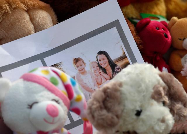 A photograph sits amid the tributes outside the home where a pregnant woman and her two daughters lived. (AP Photo/David Zalubowski)