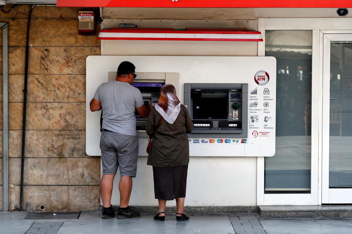 People withdraw money from a bank ATM in Izmir, Turkey on Aug. 18, 2018. (Reuters/Osman Orsal)