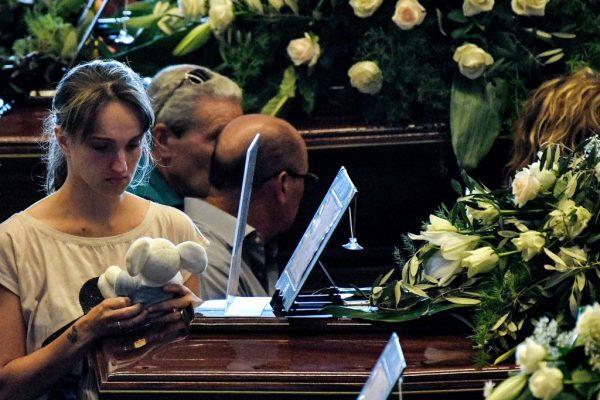 A relative holds a teddy bear as she mourns near the coffin of a victim of the collapsed Morandi highway bridge, prior to the start of the funeral service, in Genoa, on Aug. 18, 2018. (Piero Cruciatti/AFP/Getty Images)
