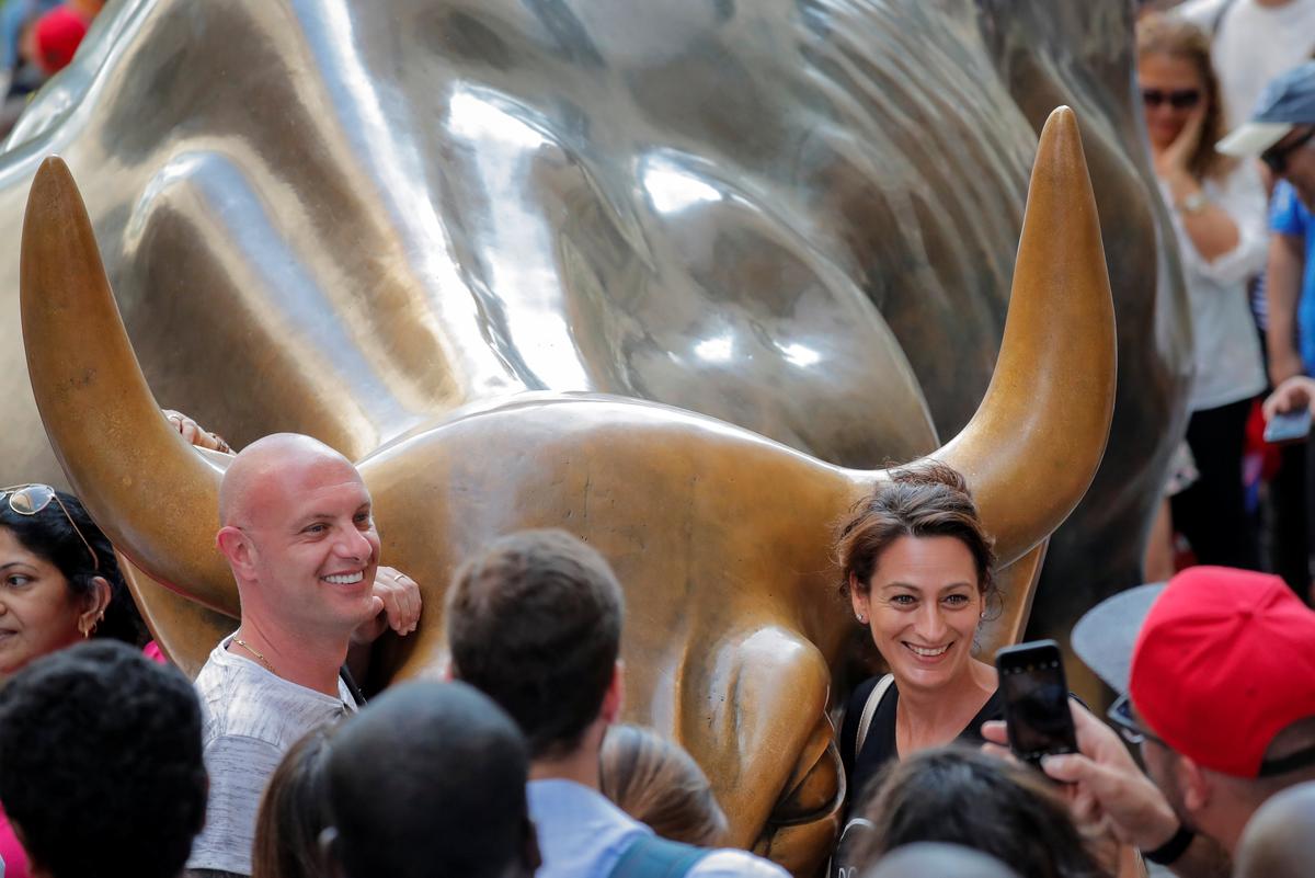 Tourists gather around the Charging Bull statue, also known as the Wall St. Bull, in the financial district of New York City on Aug. 18, 2018. (Reuters/Brendan McDermid)