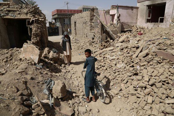 Afghan residents walk near destroyed houses after a Taliban attack in Ghazni on Aug. 16, 2018. (Zakeria Hashimi/AFP/Getty Images)