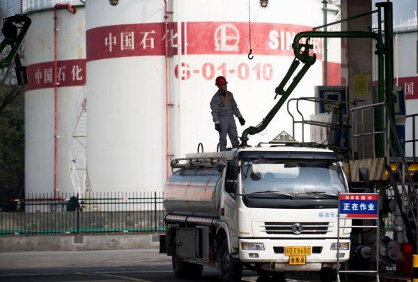 A man works at a filling station of Sinopec, China's state-owned oil company, in Shanghai, on March 22, 2018. (Johannes Eisele/AFP/Getty Images)