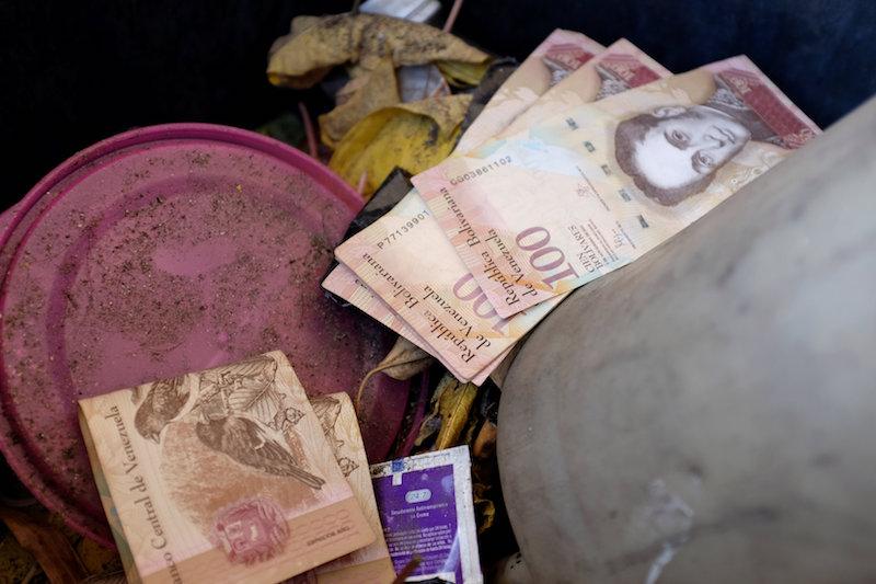 Venezuelan 100 bolivar notes thrown by people in a trash bin are seen at a gas station of the Venezuelan state-owned oil company PDVSA in Caracas, Venezuela August 20, 2018. (Reuters/Marco Bello)