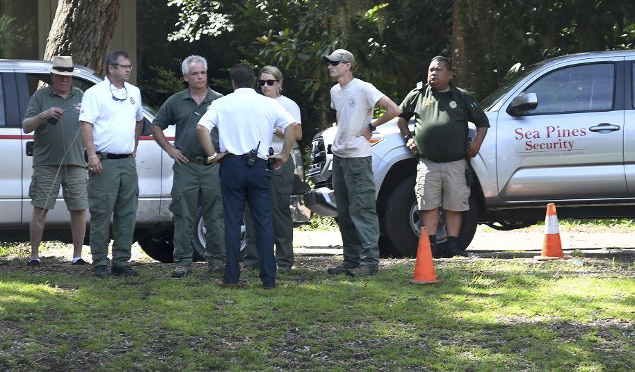 Law enforcement with Sea Pines Security, South Carolina Department of Natural Resources, and the Beaufort County Sheriff's Office stand near where authorities say Cassandra Cline was dragged into a lagoon by an alligator and killed while trying to save her dog on Hilton Head Island, South Carolina on Aug. 20, 2018. (Drew Martin/The Island Packet via AP)