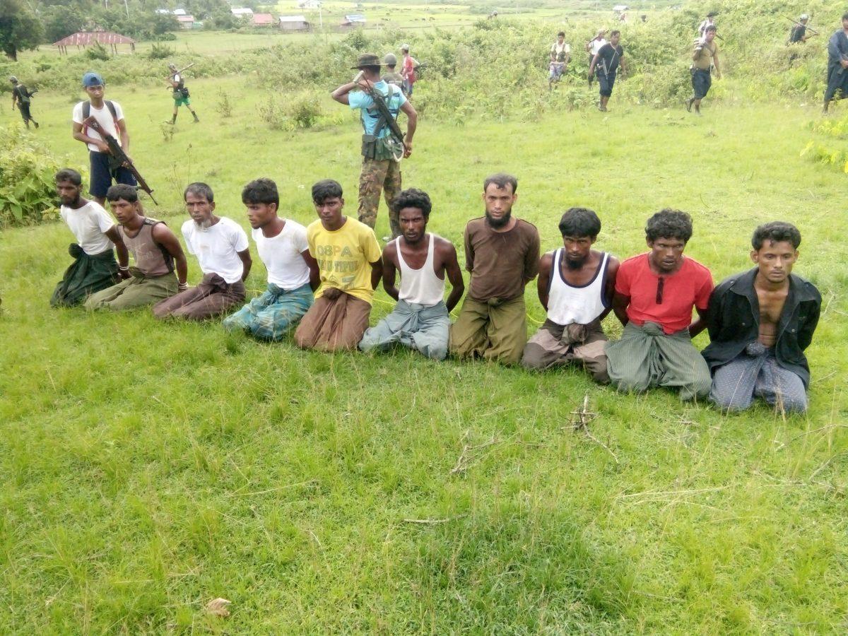 Ten Rohingya men with their hands bound kneel as members of Burmese security forces stand guard in Inn Din, Burma, on Sept. 2, 2017. Pictures reportedly later emerged of the same men’s bodies in a shallow grave, having been hacked and shot to death. (File Photo/Reuters)