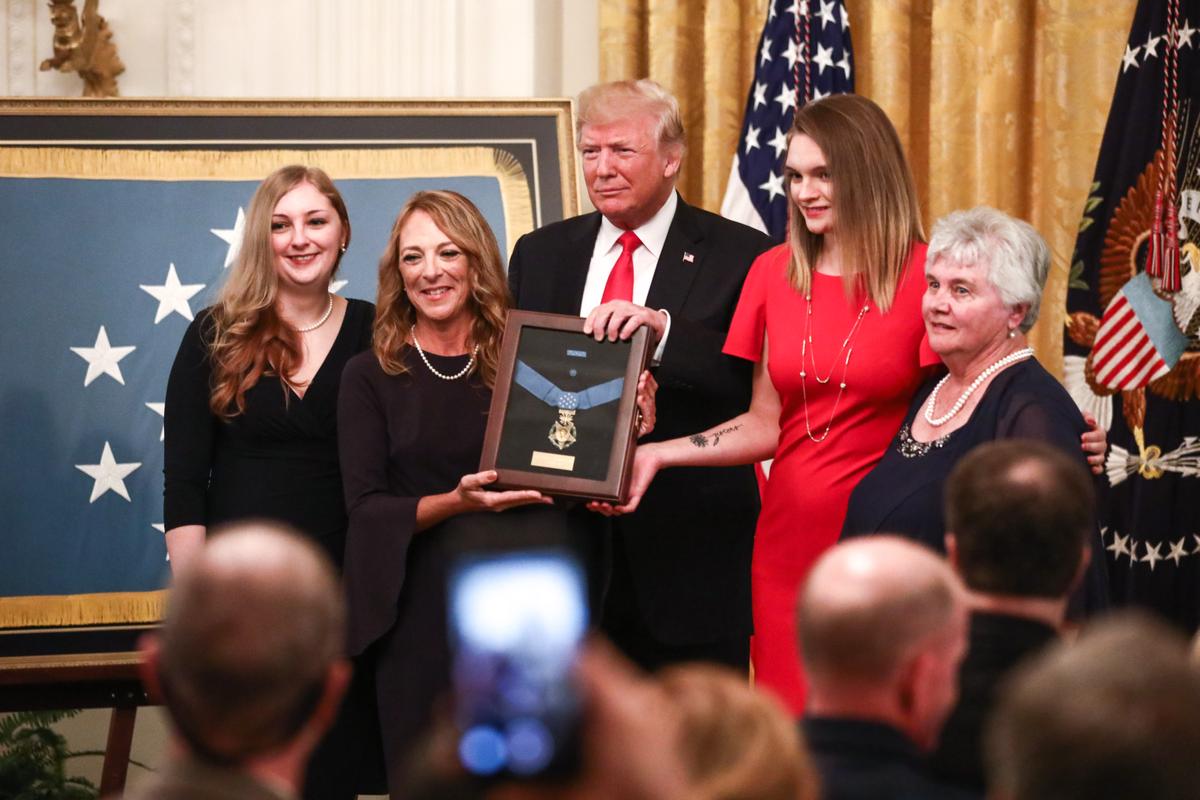 President Donald Trump presents the Medal of Honor posthumously to Valerie Nessel (2nd L), the widow of Air Force Tech. Sgt. John A. Chapman, for conspicuous gallantry, at the White House on Aug. 22, 2018. (Samira Bouaou/The Epoch Times)