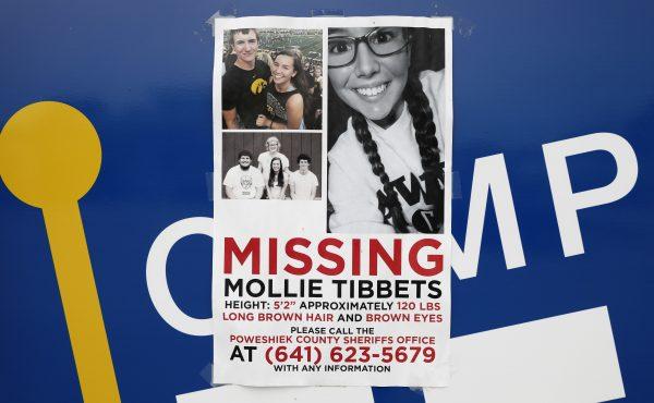 A poster for missing University of Iowa student Mollie Tibbetts hangs on the front door of a local business, Tuesday, Aug. 21, 2018, in Brooklyn, Iowa. (AP Photo/Charlie Neibergall)