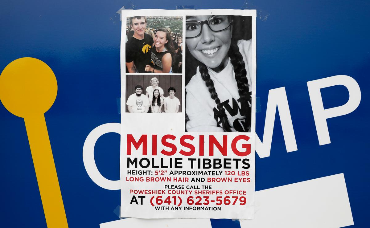 A poster for missing University of Iowa student Mollie Tibbetts hangs on the front door of a local business in Brooklyn, Iowa on Aug. 21, 2018. (AP Photo/Charlie Neibergall)