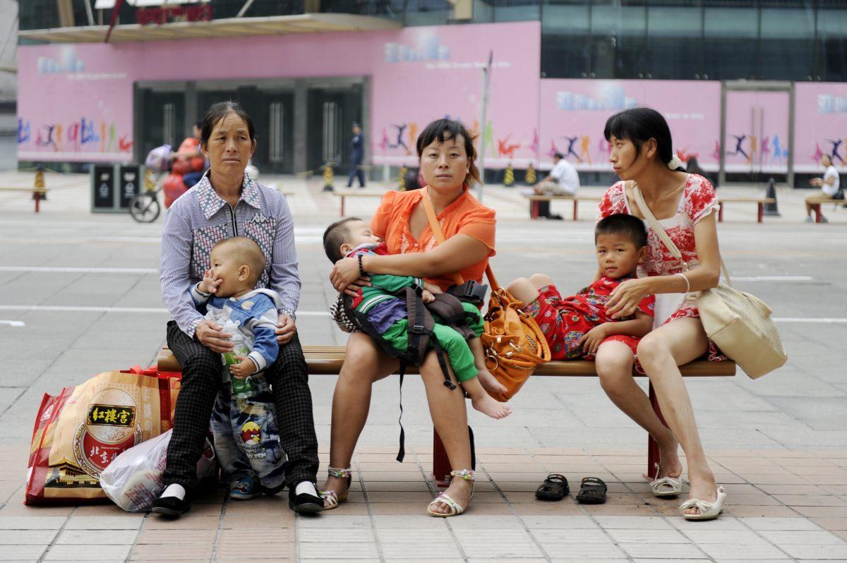 Women sit on a bench with their children on a street in Beijing, on Sept. 6, 2012. (Wang Zhao/AFP/Getty Images)