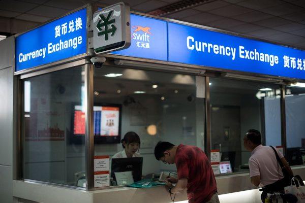 A man changes foreign currency into Chinese yuan at a currency exchange office in Hongqiao Airport in Shanghai, China, on Aug. 14, 2015. (Johannes Eisele/AFP/Getty Images)