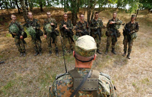 German Bundeswehr recruits receive a debriefing by an instructor during a drill at a military training area in Viereck, Germany, on Aug. 8, 2018. (Reuters/Fabrizio Bensch)