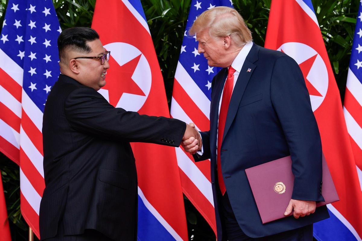 U.S. President Donald Trump and North Korea's leader Kim Jong Un shake hands during the signing of a document after their summit at the Capella Hotel on Sentosa island in Singapore June 12, 2018. (Susan Walsh/Pool via Reuters/File Photo)