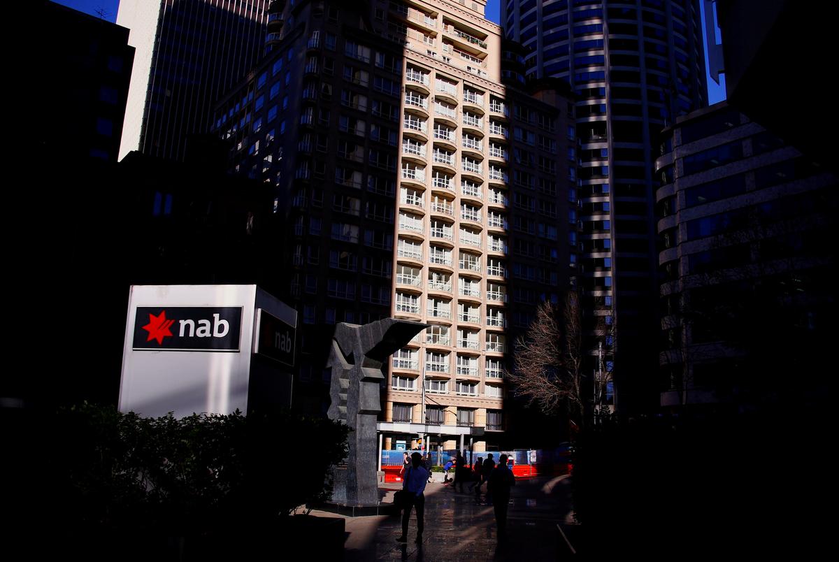 File photo: Pedestrians walk past the logo of National Australia Bank which is displayed outside their headquarters building in central Sydney, Australia August 4, 2017. (Reuters/David Gray/File Photo)