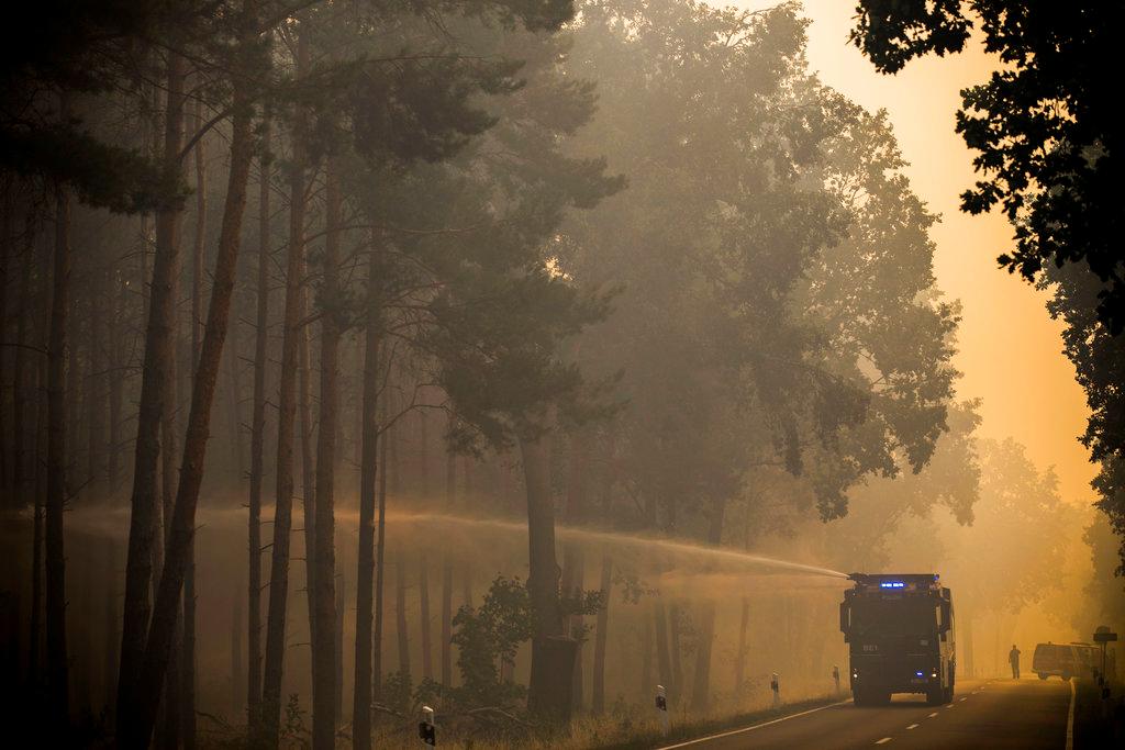 A police water cannon sprays water into a forest near Treuenbrietzen, south of Berlin, Friday, Aug. 24, 2018 after a trees on an area of several hundred soccer fields caught fire. (Michael Kappeler/dpa/AP)