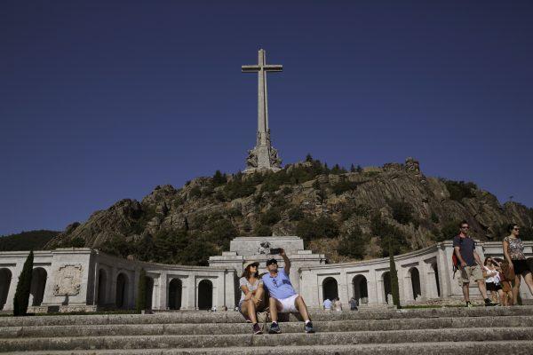 A couple take a photo at the Valley of the Fallen monument at El Escorial, in El Escorial, Spain, on Aug. 24, 2018. (AP Photo/Andrea Comas)