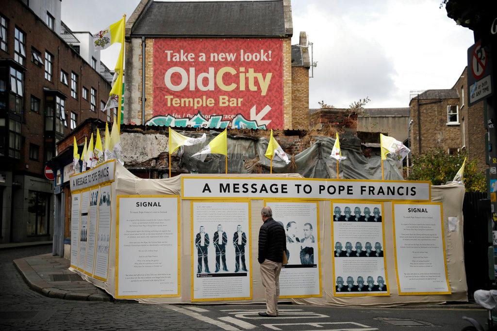  A passerby looks at an art installation by Mannix Flynn protesting the Pope's visit in Dublin, Ireland, Thursday, Friday, Aug. 24, 2018. When St. John Paul II visited Ireland in 1979, the Catholic Church wielded such power that homosexuality, divorce, abortion and contraception were barely spoken of, much less condoned. Catholic bishops had advised the authors of Ireland's constitution, and still held sway. Today, as Pope Francis prepares to visit, the Catholic Church enjoys no such influence. (AP/Matt Dunham)