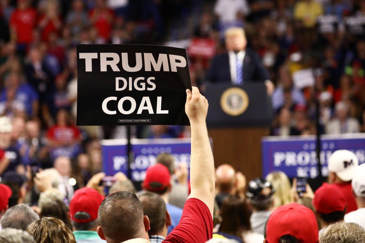 A man holds a sign as President Donald Trump speaks at a Make America Great Again rally in Charleston, W. Va., on Aug. 21, 2018. (Charlotte Cuthbertson/The Epoch Times)