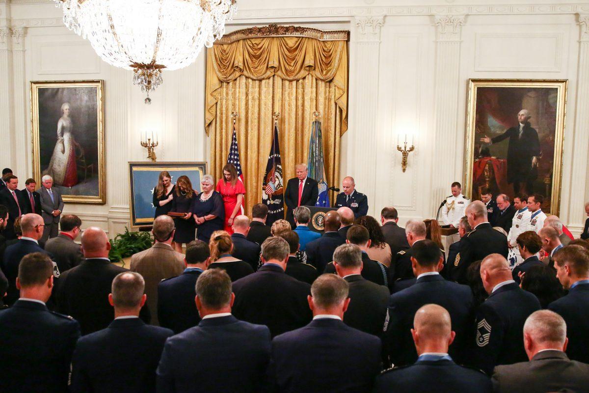 President Donald Trump and Air Force Tech. Sgt. John A. Chapman's family pray during a Medal of Honor ceremony in the East Room at the White House in Washington on Aug. 22, 2018. (Samira Bouaou/The Epoch Times)