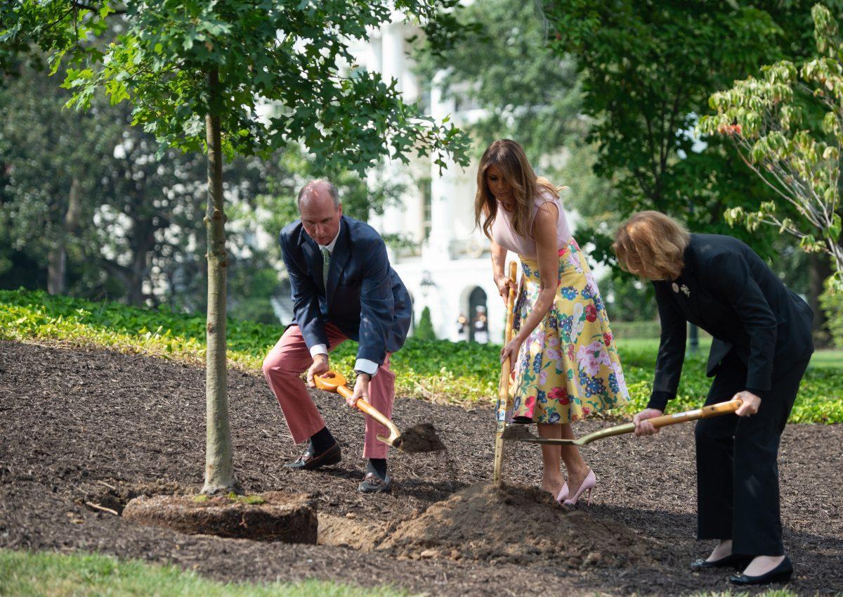 First Lady Melania Trump participates in a tree planting ceremony alongside Mary Jean Eisenhower, granddaughter of President Dwight Eisenhower and Richard Emory Gatchell, Jr., a fifth generation grandson of President James Monroe (L). The trio shovel soil on a sapling from the original Eisenhower Oak tree that was removed from the grounds last year, on the South Lawn of the White House in Washington, on Aug. 27, 2018, (SAUL LOEB/AFP/Getty Images)