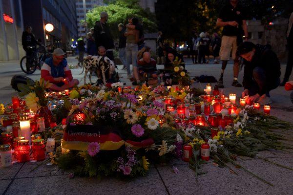 People place flowers and light candles at the site where a German man was stabbed last weekend in Chemnitz, Germany,  on Aug. 27, 2018. (Matthias Rietschel/Reuters)