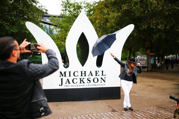 A fan has her photograph taken next to a giant crown installed to celebrate the diamond birthday of Michael Jackson, on the South Bank in London, Britain August 29, 2018. (Reuters/Henry Nicholls)