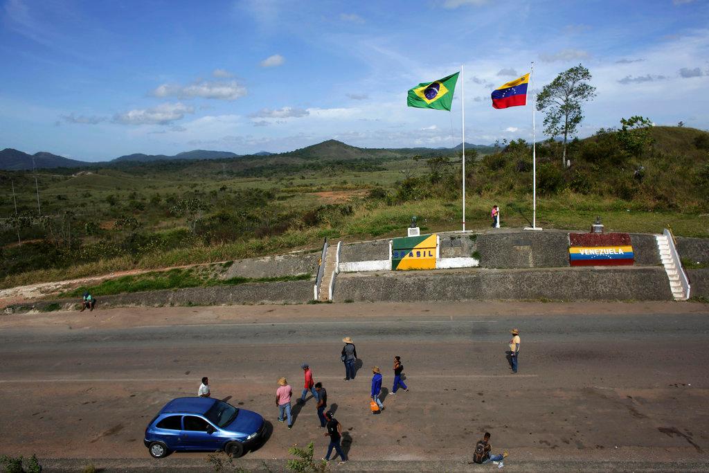 File photo: In this March 10, 2018 file photo, people stand at the border between Venezuela, right, and Brazil, near the Brazilian city of Pacaraima, in Roraima state. The poor state in northern Brazil, which is at the center of the Venezuelan migrant crisis, had the highest homicide rate in Brazil in the first six months of the year, according to data published Tuesday, Aug. 28, 2018. (AP/Eraldo Peres/File)
