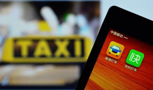 A smartphone shows the two apps, Kuaidi Dache–part-owned by Alibaba–and Didi Dache– backed by Tencent–which together control 99 percent of China's domestic market for booking taxis by smartphone, being display in Hangzhou, China's Zhejiang Province on Feb. 14, 2015. (STR/AFP/Getty Images)